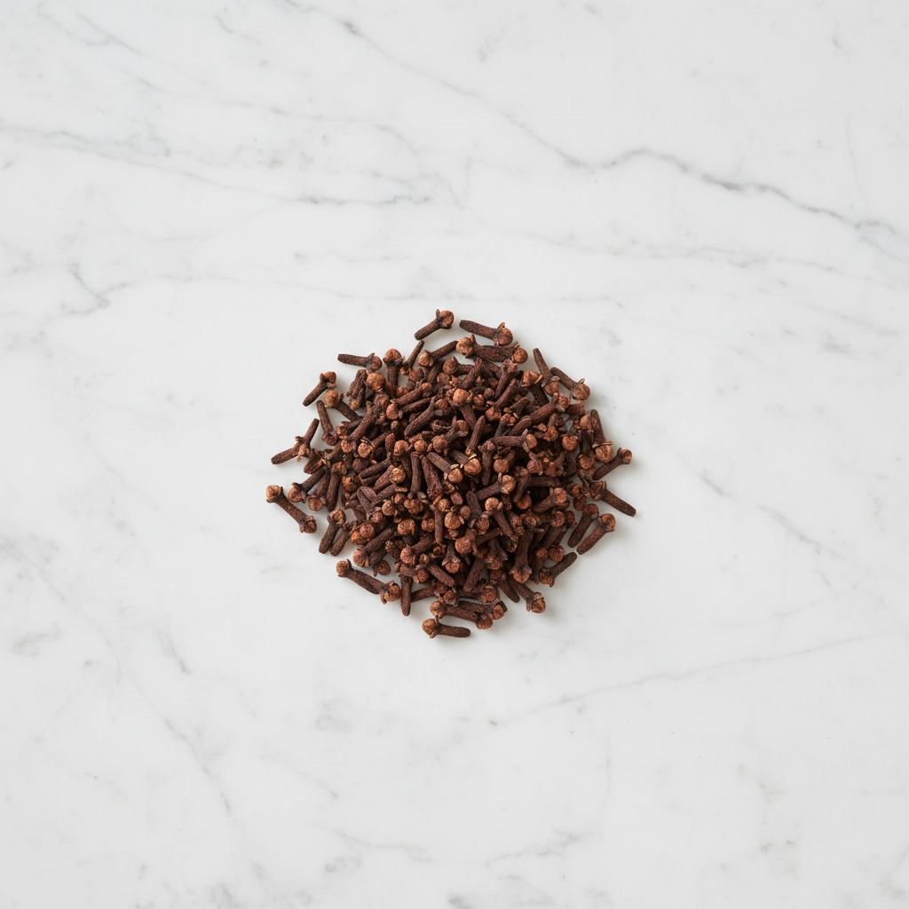 Maison Gabrielle Whole Cloves Piled on a White Marble Surface for Aromatic Cooking and Baking Recipes
