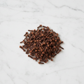 Maison Gabrielle Premium Whole Cloves Spice Piled on a White Marble Surface for Aromatic Culinary Recipes and Baking